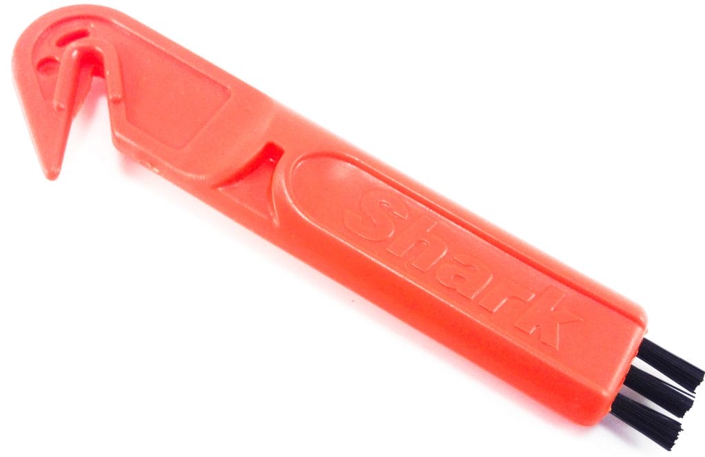 Image shows the cleaning tool that is supplied. It's red with black bristles.