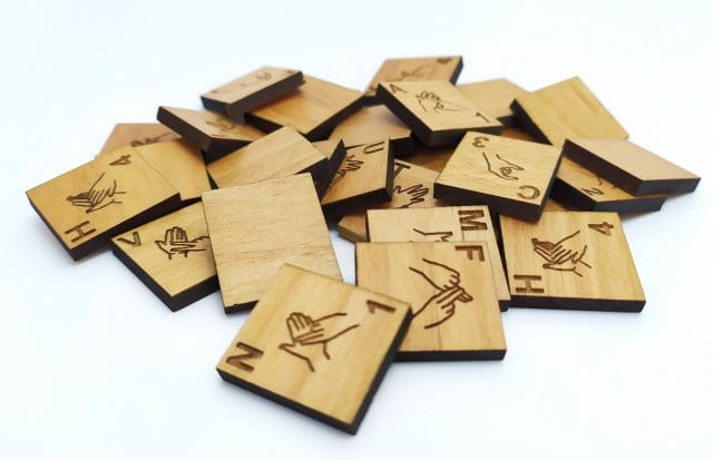 Pile of wooden British Sign Language Scrabble tiles