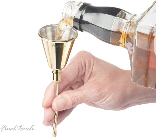Image shows a drink being poured into the jigger of the spoon.