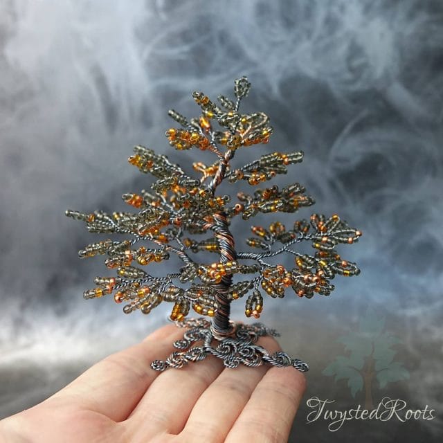 Image shows my tree upon a hand with a dark grey smokey backdrop.