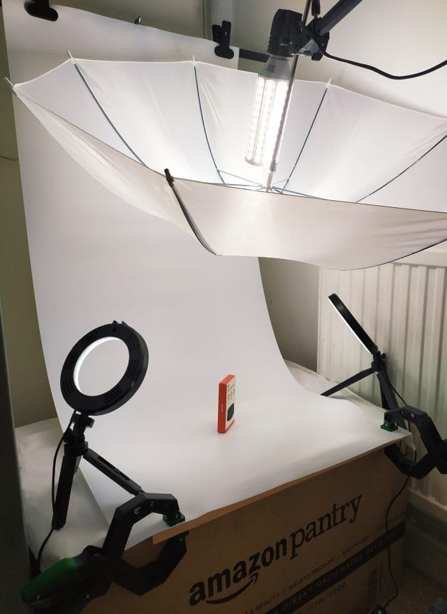Image shows my setup. There's an umbrella with LED light over a White backdrop.
