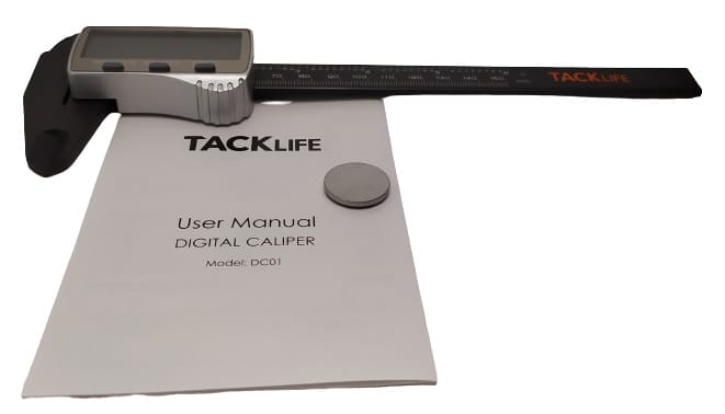 Image shows the caliper, battery and user guide in a laid out position.
