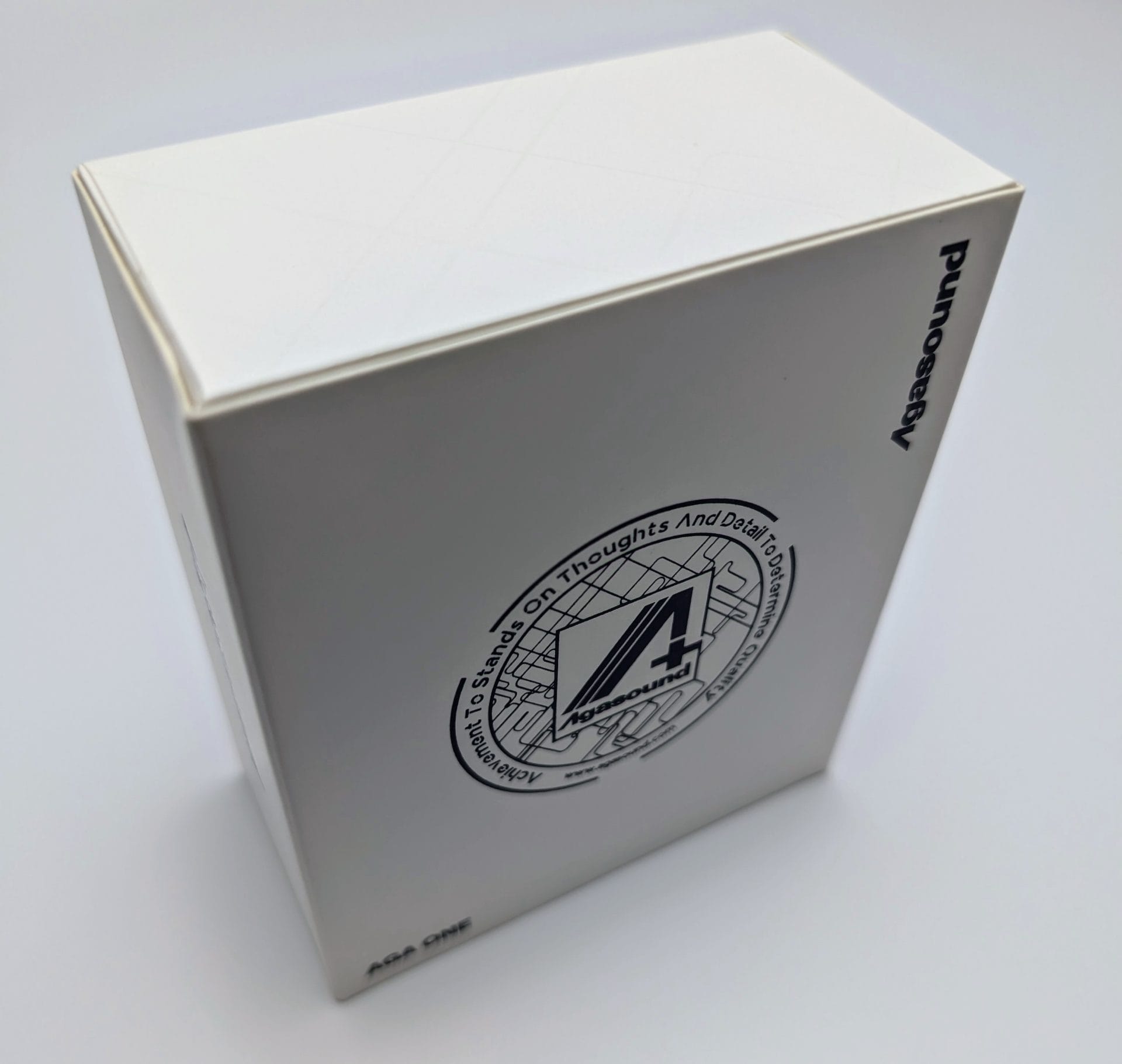 Agasound AgaOne IEMs Here's the alt text for the attached image of the Agasound AgaOne IEMs packaging: "A white rectangular box with the Agasound logo and the text 'Agasound AgaOne' printed on it. The logo features a stylized '4' with the words 'Attention to Thoughts And Detail Top to Bottom' surrounding it in a circular pattern. The brand 'Agasound' is printed vertically on the side of the box."