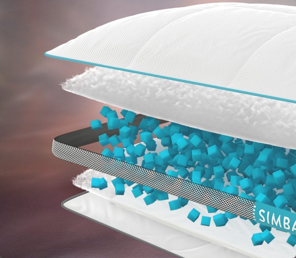 Cross-sectional view of the Simba Hybrid Pillow, showcasing its multi-layer design. The pillow features a soft white outer cover with a teal trim, a fluffy inner filling layer, and a central section filled with small blue gel-infused cubes for support. A breathable mesh layer separates the cubes, enhancing airflow and comfort. The Simba logo is visible on the side.