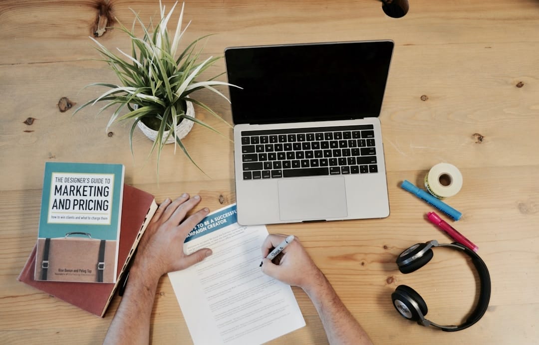 An employee doing market research and writing it down to develop strategic account planning for his company.