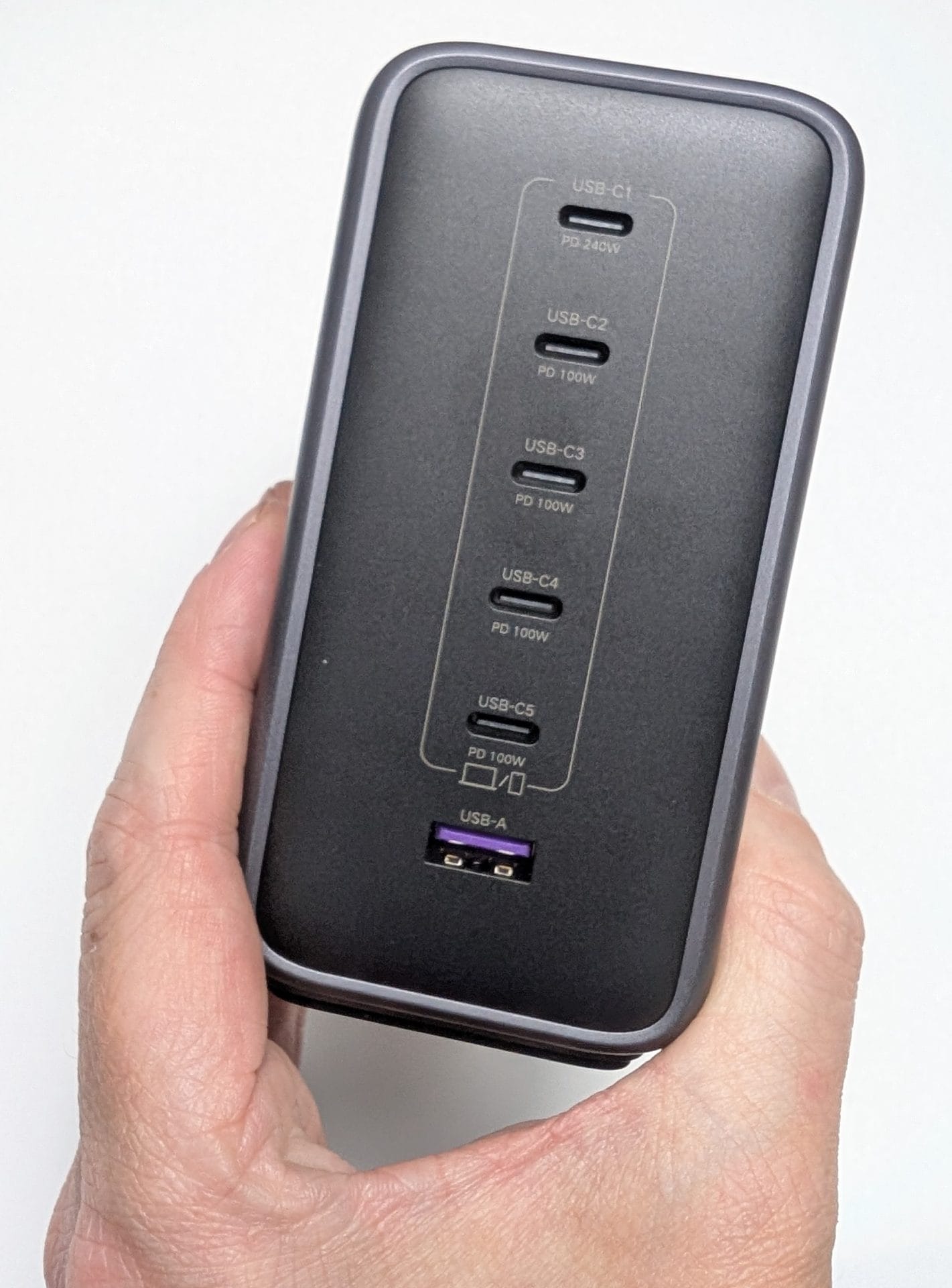 A hand holding the UGREEN Nexode 500W 6-Port GaN Desktop Charger in grey, showing the port side. It features five USB-C ports (USB-C1: PD 240W, USB-C2 to C5: PD 100W) and one USB-A port (15W), with labels indicating their power delivery capabilities. The image was captured on 31 May 2025 at 12:33 PM BST.