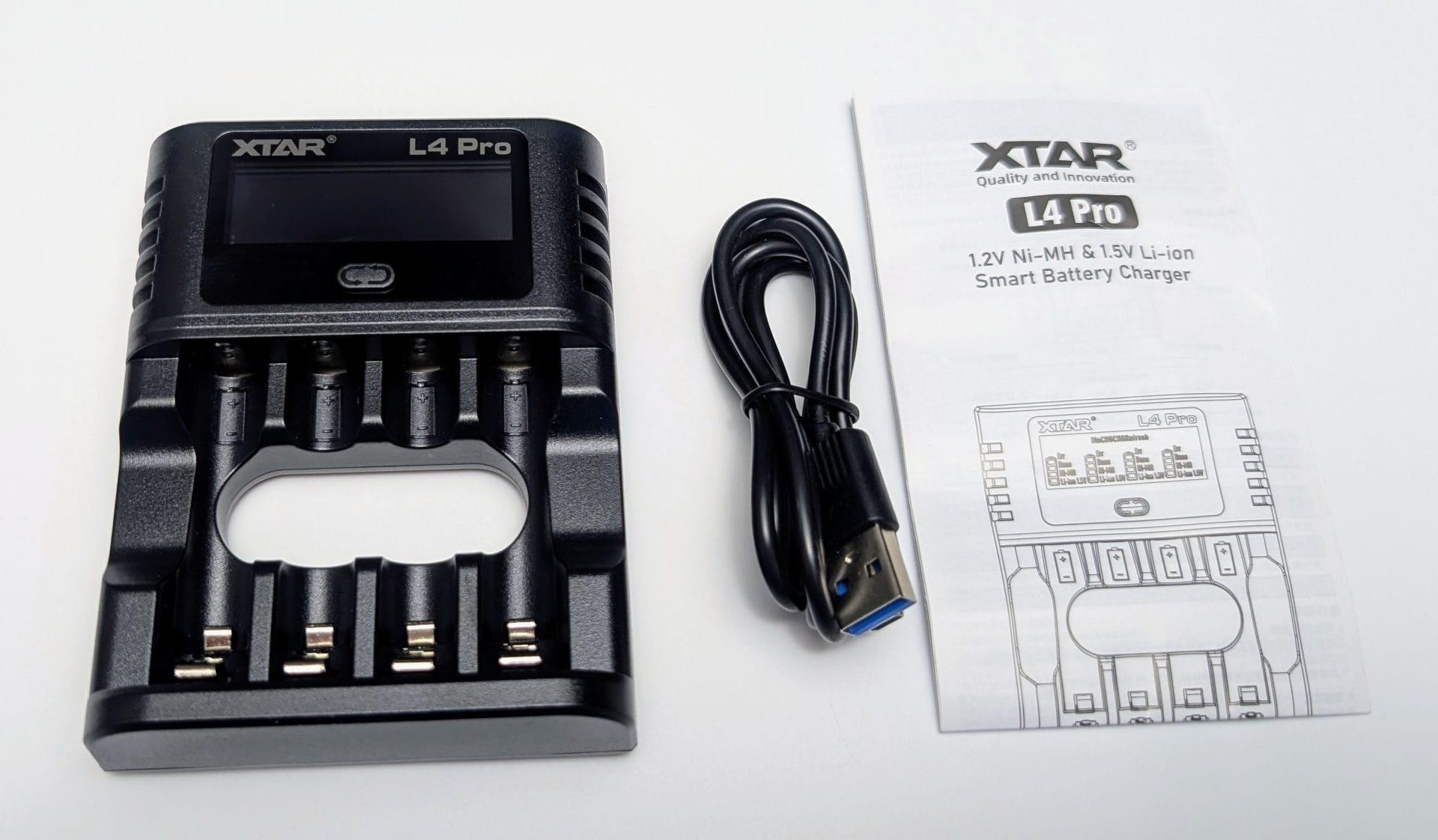 XTAR L4 Pro Smart Battery Charger set, including a black charger with a digital display and four battery slots, a USB cable, and a user manual with a diagram. The charger is designed for 1.2V Ni-MH and 1.5V Li-ion AA/AAA batteries, placed on a white background.