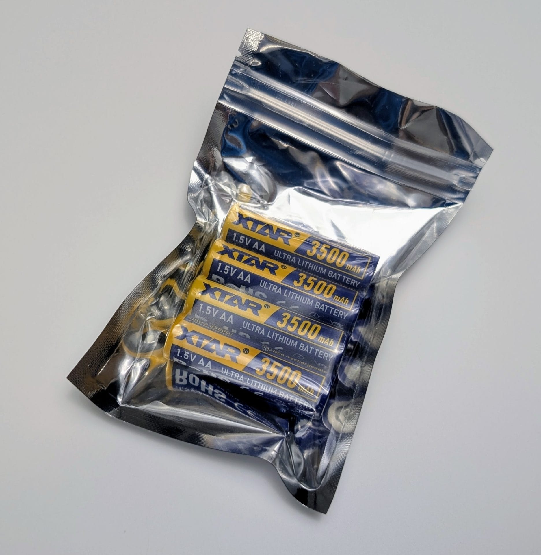 XTAR Ultra3500D AA Lithium 3500mAh Non-Rechargeable Batteries A sealed, metallic zip-lock bag containing four XTAR Ultra3500D AA lithium non-rechargeable batteries. Each battery is yellow with blue and white text, labeled "XTAR Ultra Lithium Battery," "1.5V AA," and "3500 mAh." The packaging is placed on a plain, light grey surface.