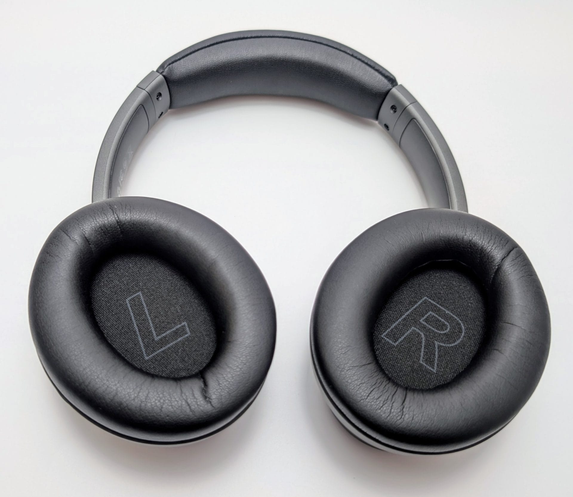 Kiwi Ears Ardor A pair of Kiwi Ears Ardor headphones viewed from the front, showing black leather ear cushions with "L" and "R" markings on the left and right ear cups respectively, and a padded gray headband.